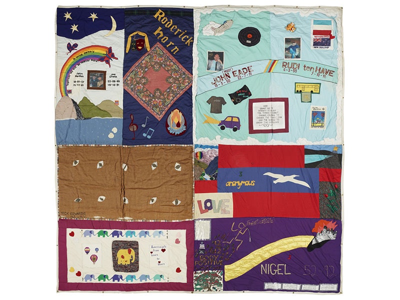 Quilt consisting of 8 vividly coloured panels dedicated to people who died of AIDS. Each panel contains a mixture of words and pictures