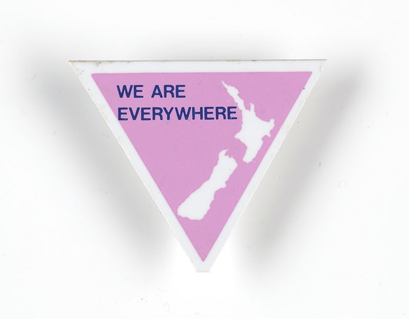 Badge in the shape of a pink triangle with a map of New Zealand on it and the words “We are everywhere”