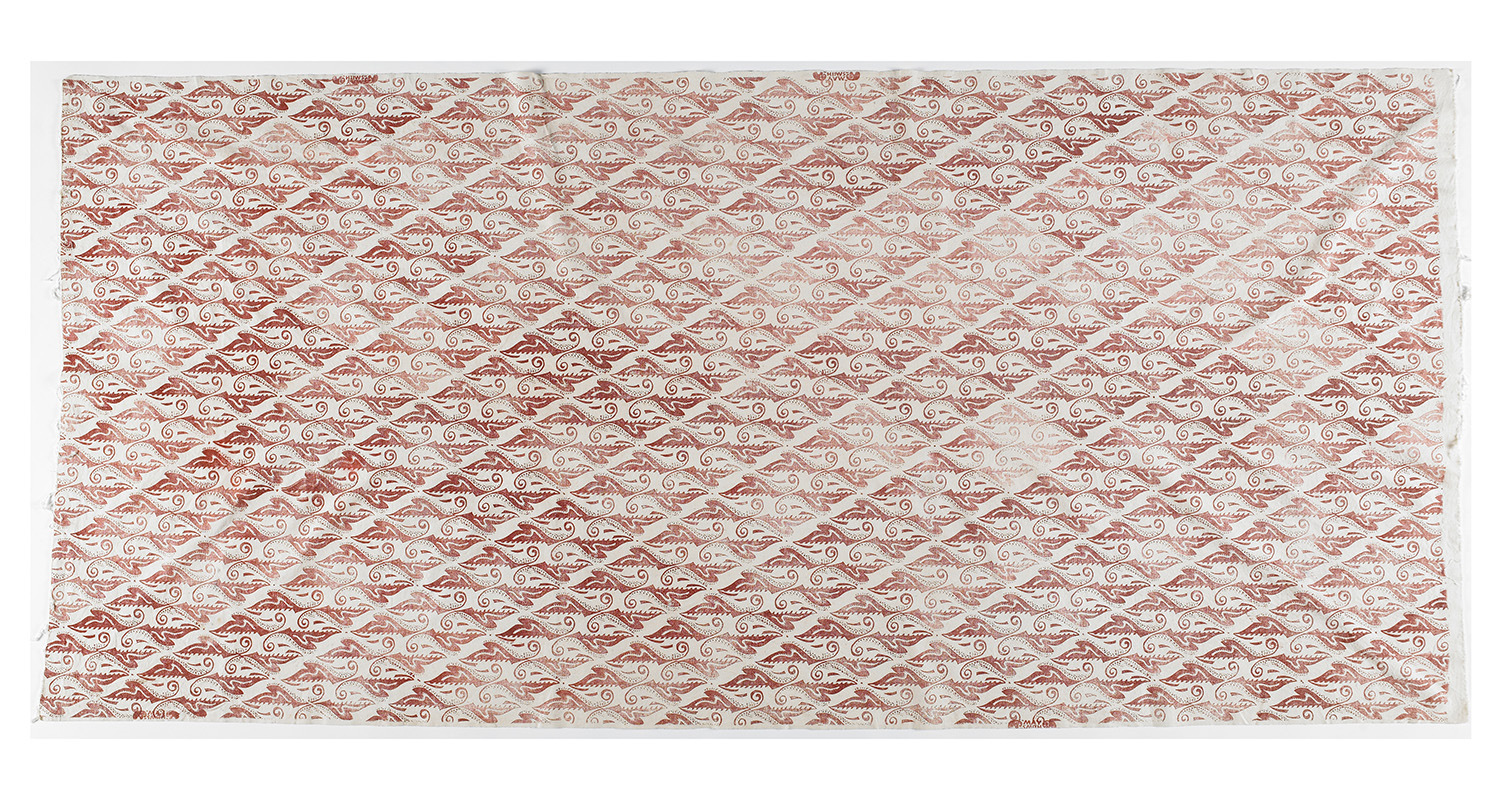 A piece of off-white material with a red pattern stamped on it