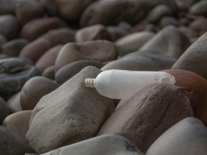 Photo by Shaun Lee A plastic bottle sits among rocks