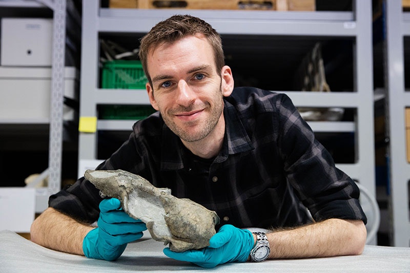 A smiling Felix Marx holds a seal skull in his hand
