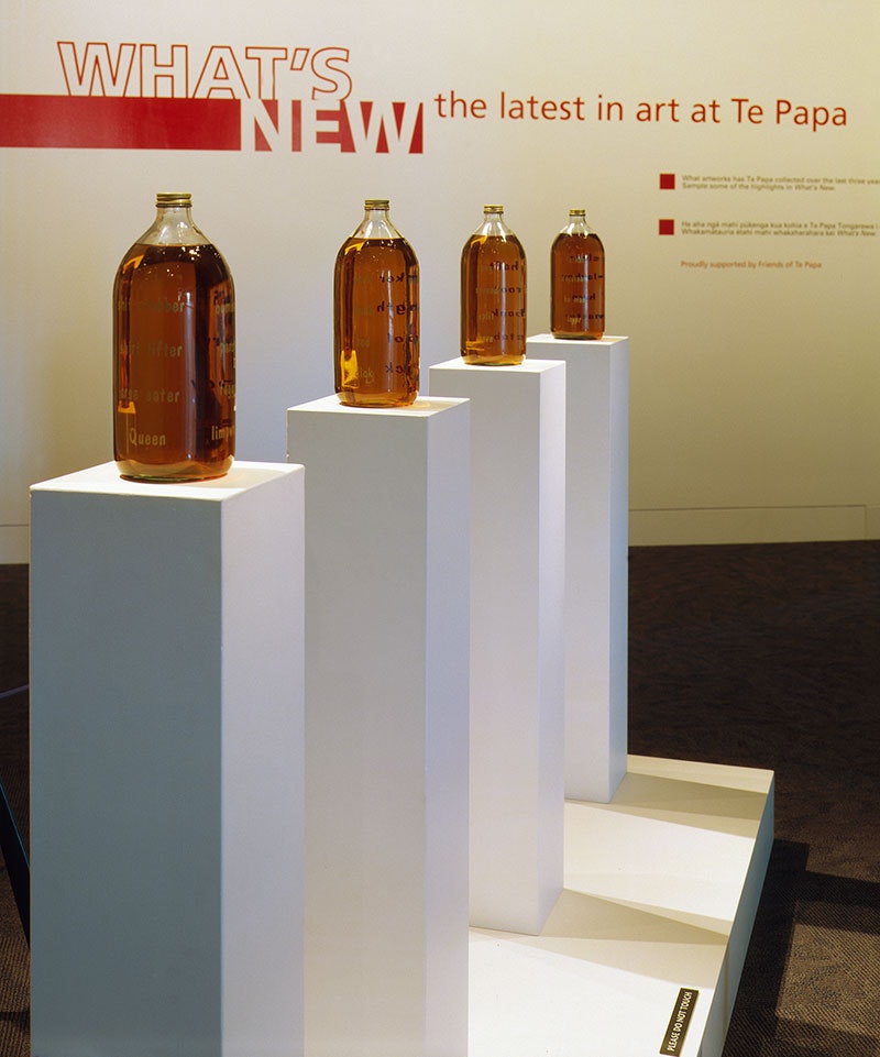 Four large bottles containing beer stand on four plinths