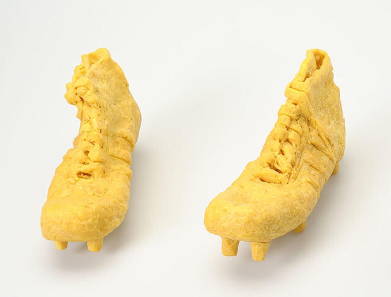 A pair of rugby boots carved out of bright yellow soap