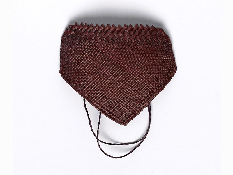 A brown face mask woven with flax on a white background