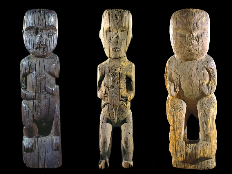 Three pou kātua, depictions of persons carved into wooden posts