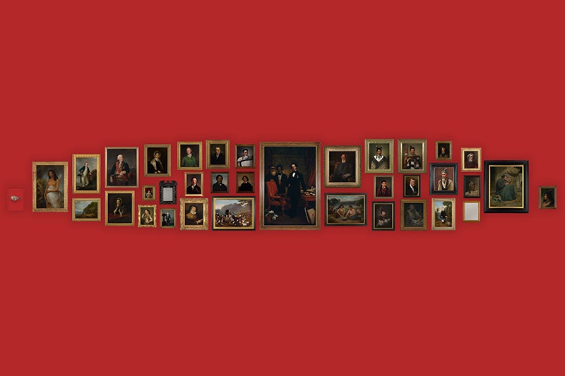 A selection of portraits lined up on a red wall