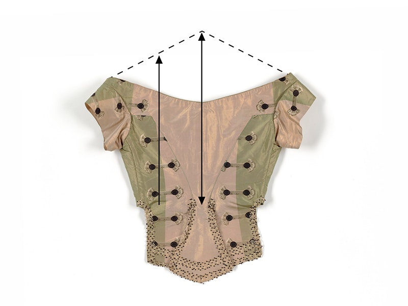 A green and fawn bodice made of silk with arrows and dotted lines showing measurements