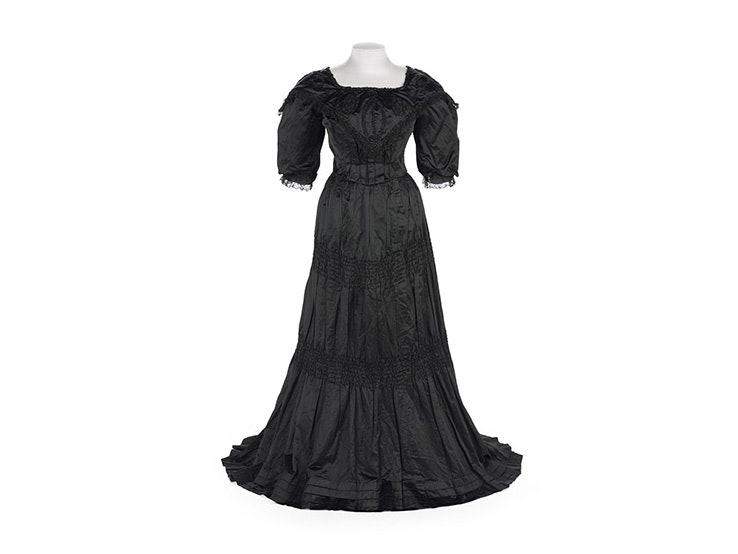 A black satin dress from the 1890s on a white background