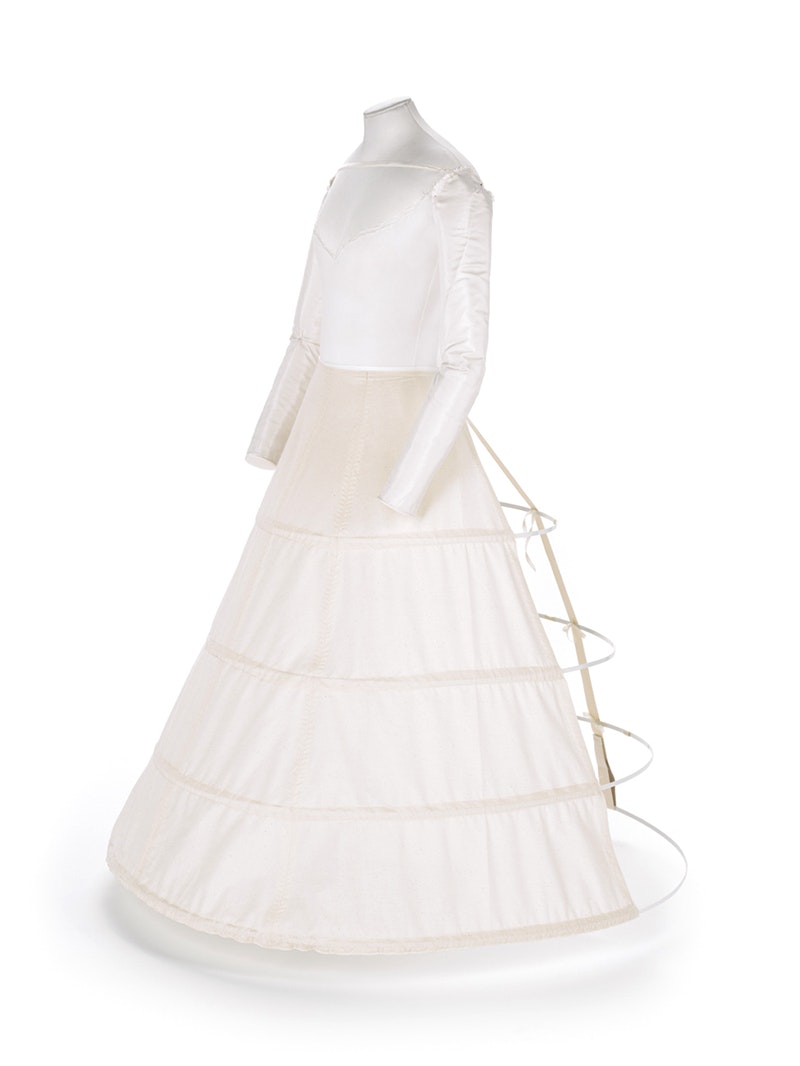 a photo of the dressmaker's dummy with padding and hoops set up for displaying a victorian dress.
