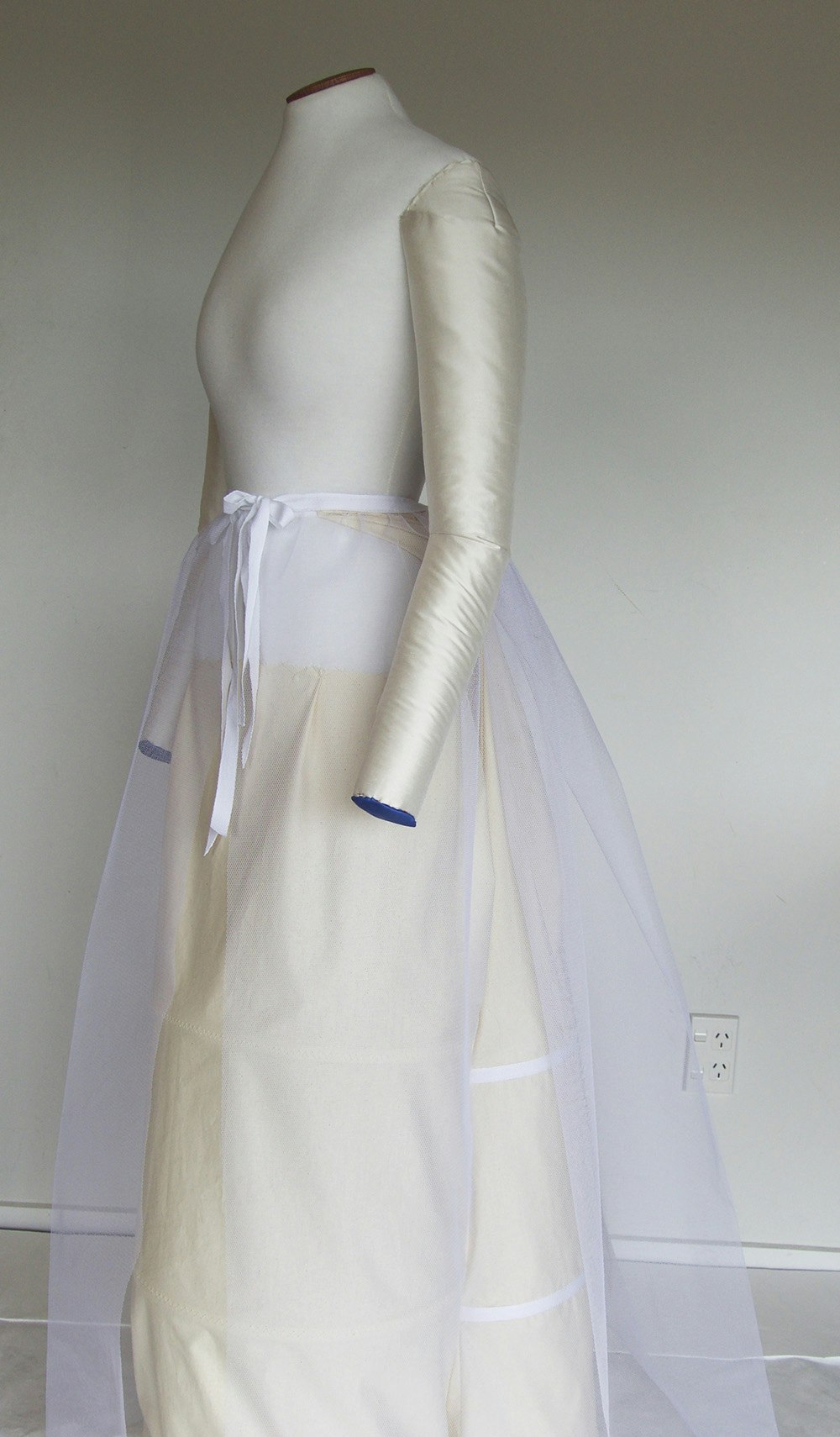 A white gauze skirt over a white dressmaker's model