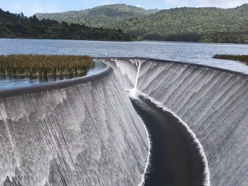 A lake with a man-made channel in the middle of it with water flowing down both sides