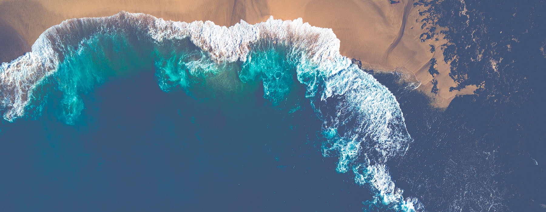 An aerial shot of waves breaking on a beach