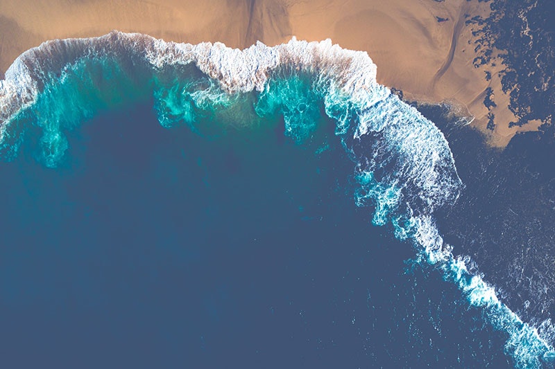 An aerial shot of waves breaking on a beach