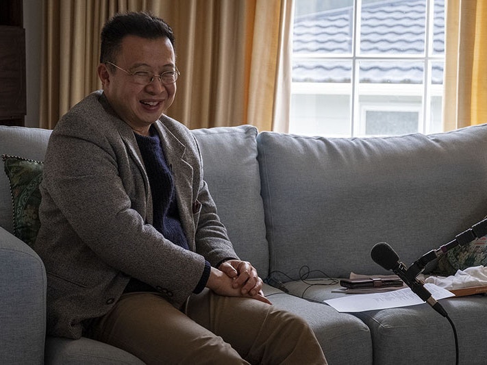 Jack Yan in his home during the film shoot, 2021. Photo by Daniel Crichton-Rouse. Te Papa Jack sits on his couch. A boom mic is in shot