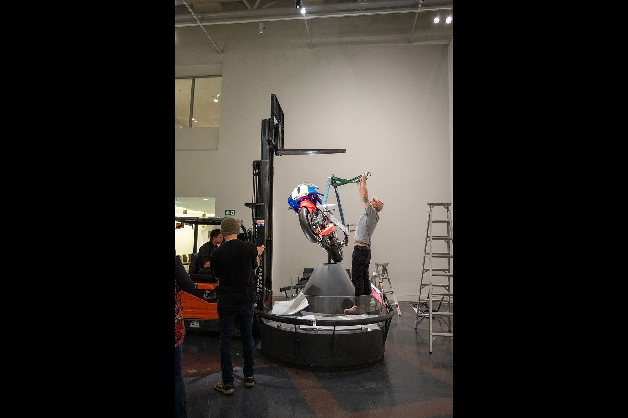 Phillip attaches cables to connect the rig on the bike to the forklift