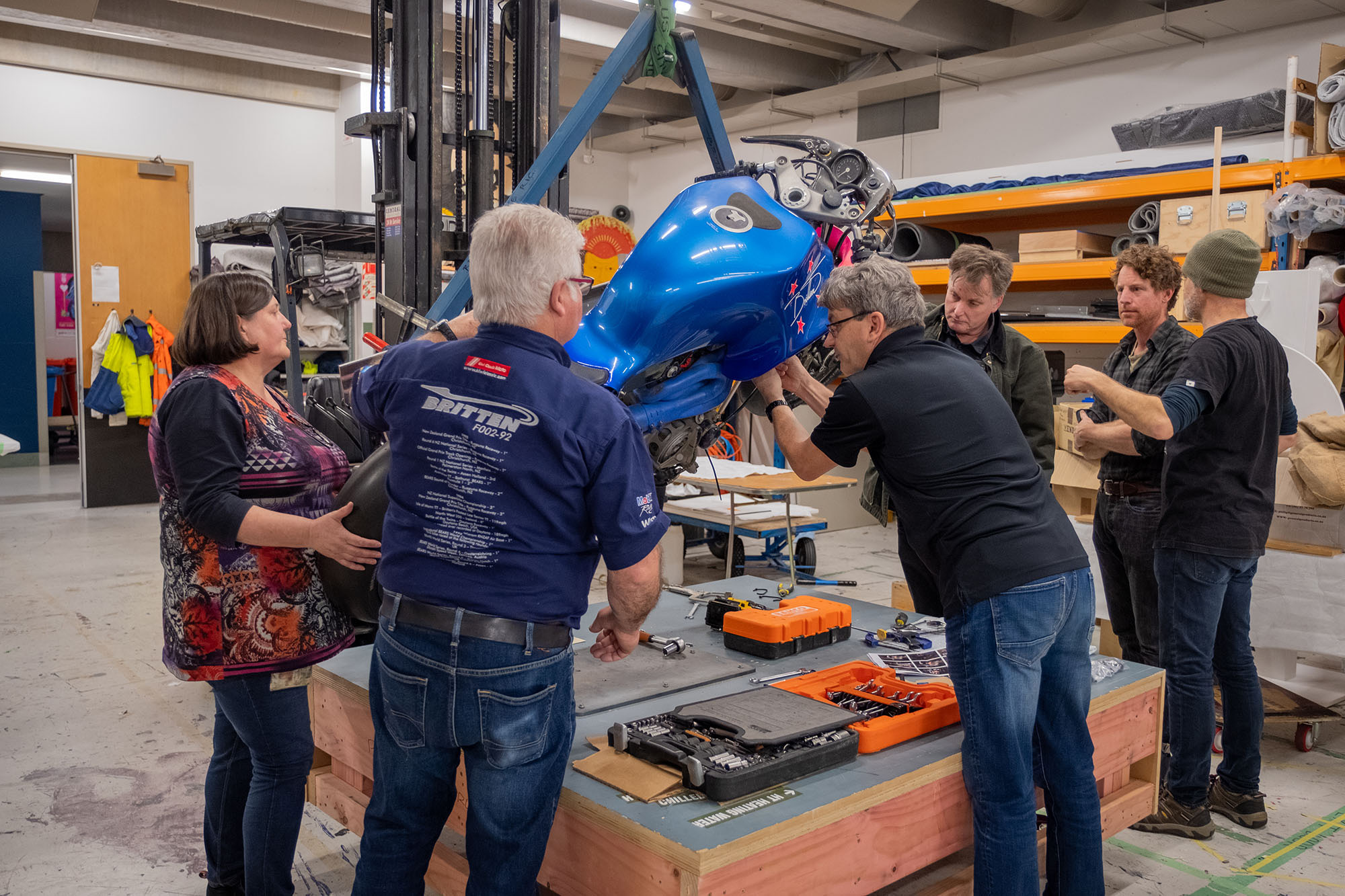 The team look on as Craig remove a piece of the bodywork