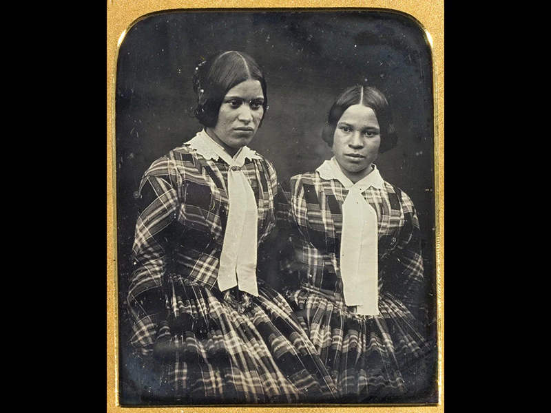 a black and white photo of two girls. The photo has a gold frame.