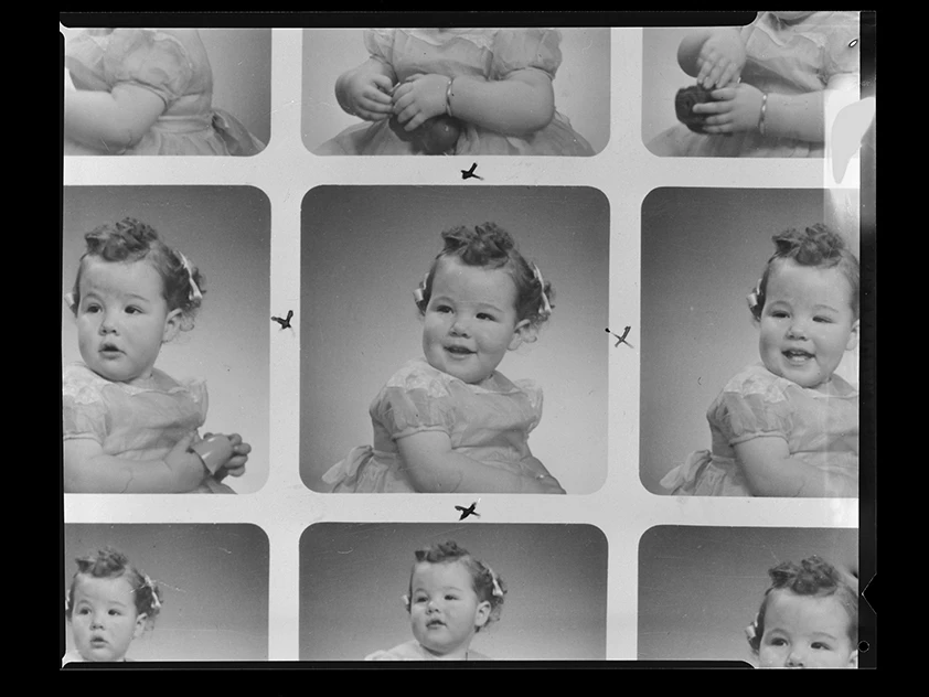 A photographic contact sheet with 9 images of a child and x marks near some of them