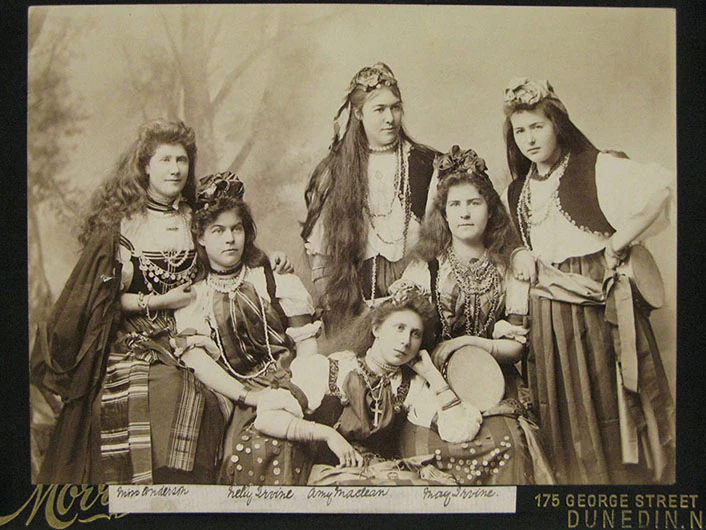 Six women posing and facing the camera in a photographic studio