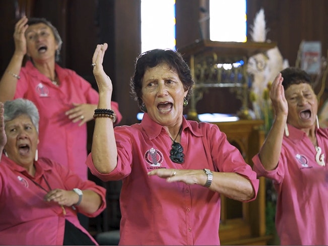 Still from Taikura Kapa Haka 2022 video series Four women in pink shirts singing with hand actions