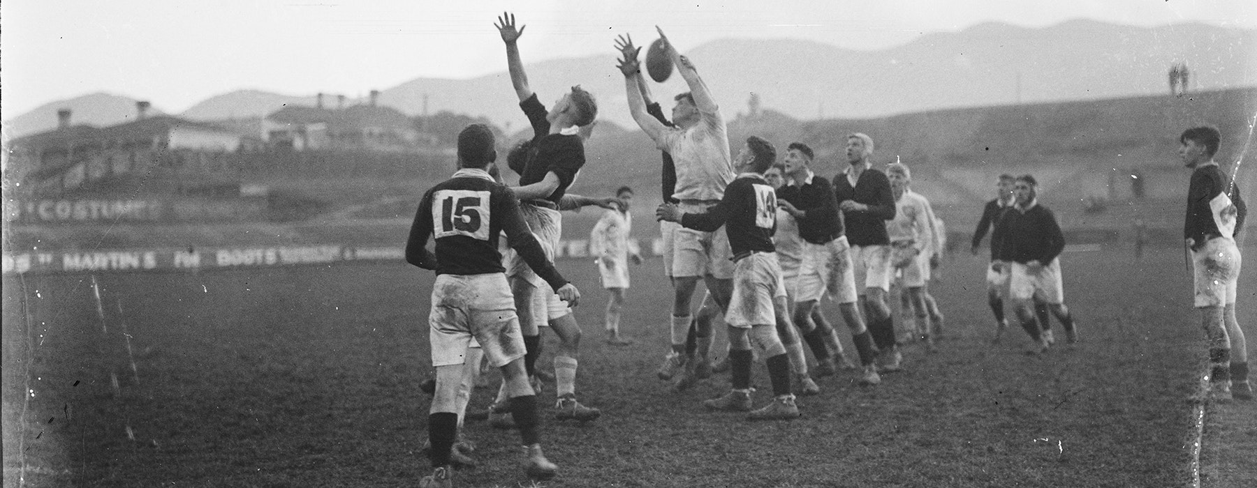 A black and white photo of two teams playing rugby