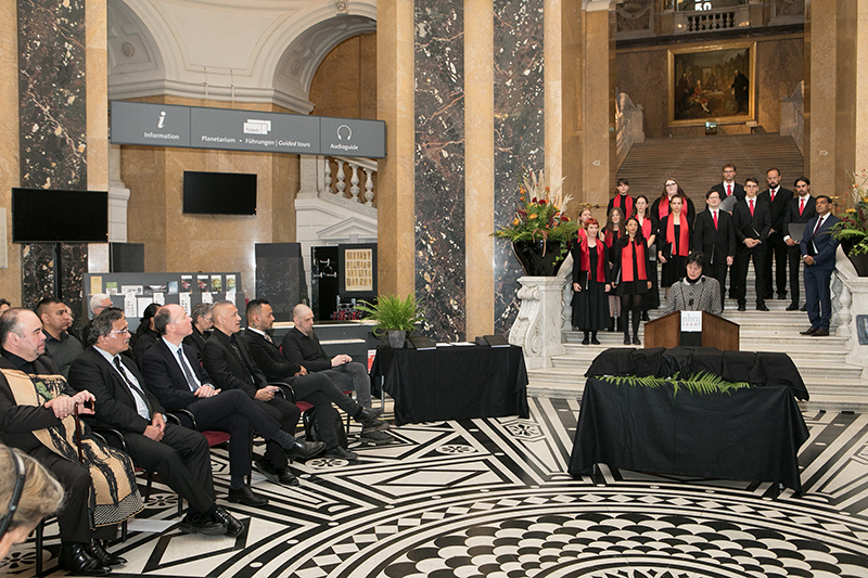 A group of people on a set of steps in a room with other people