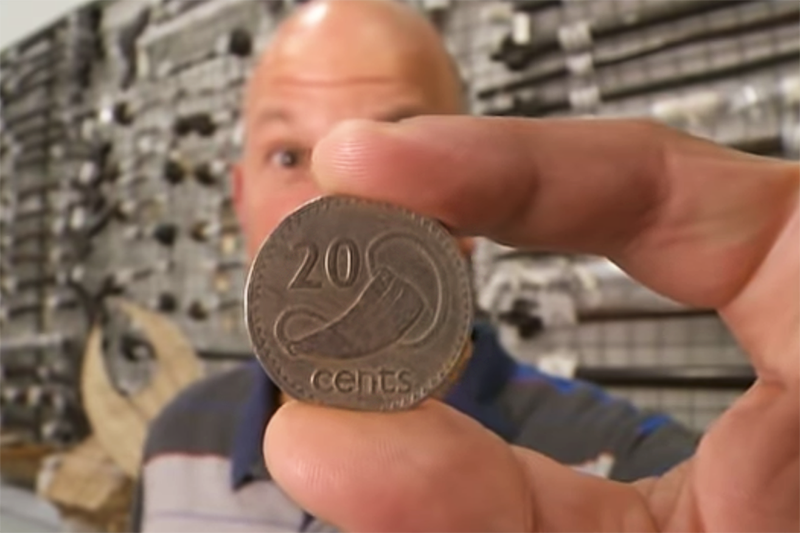 A 20 cent coin held close to the camera with someone behind it