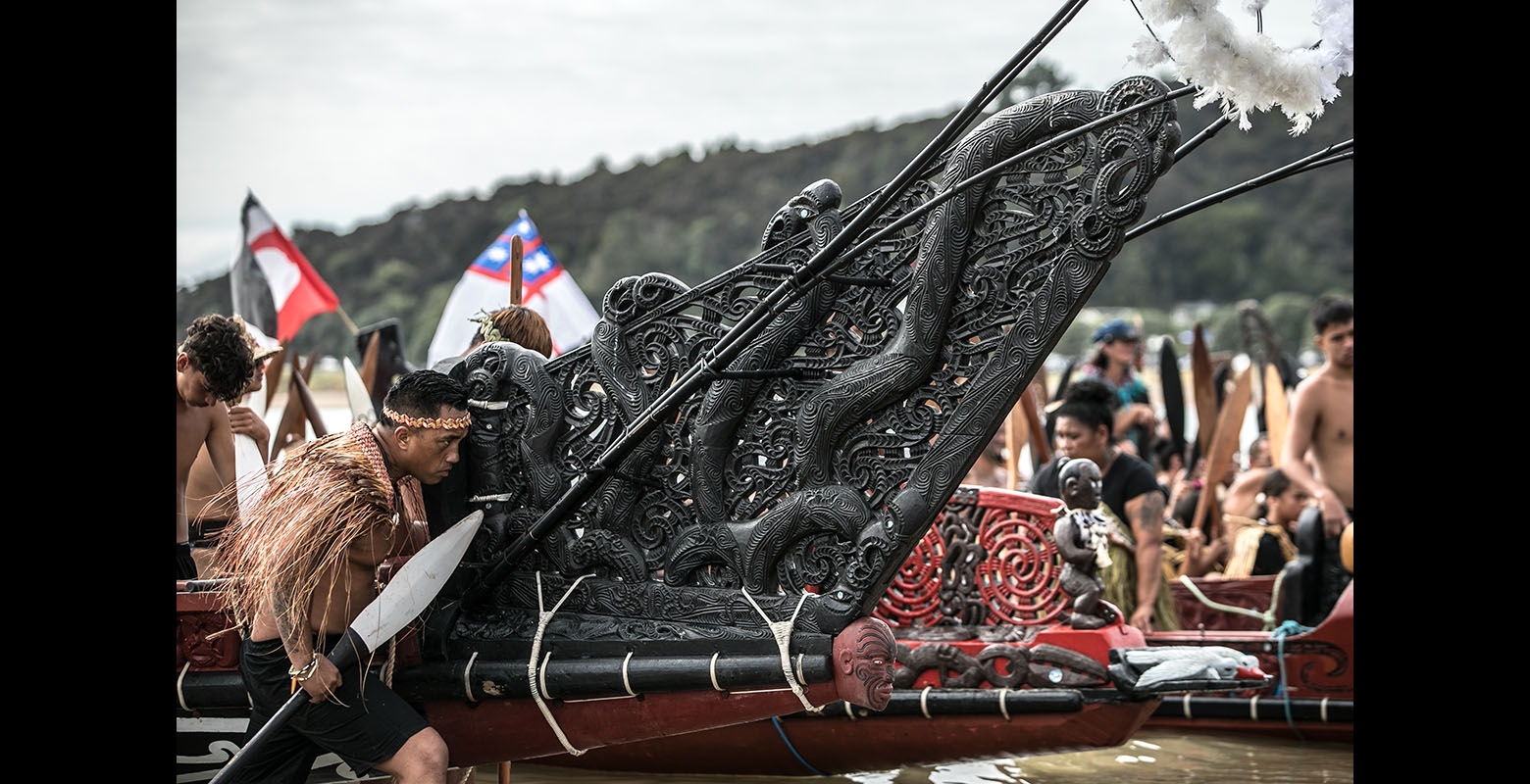 Close up of the ornate prow – front – of a waka, as it is brought to shore
