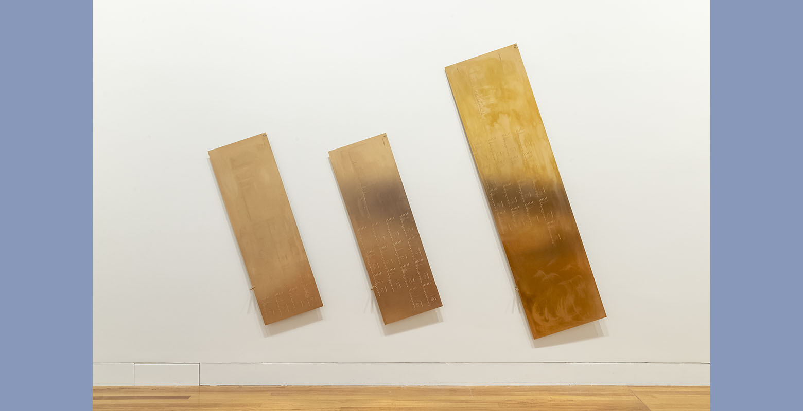 Three brass panels on a wall