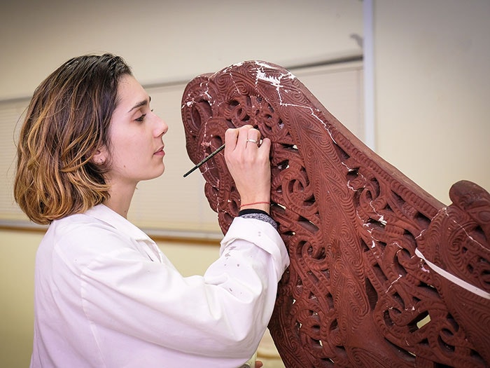 Charlotte Jimenez restoring the plaster cast replica of an 18th century tauihu (canoe prow), 2017. Photograph by Rachael Hockridge. Te Papa =""
