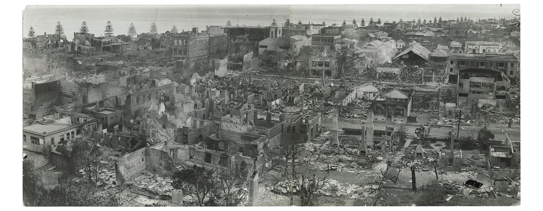 A black and white aerial photo of a city in ruins after an earthquake.