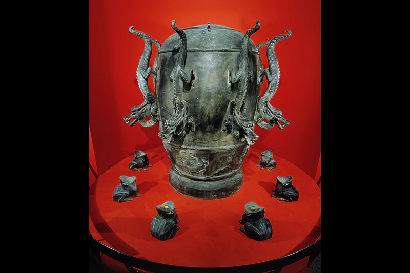 A brass object that has dragons on it - each dragon has a ball in its mouth, there are frogs under each dragon, if the ball is on the frog's open mouth instead, the earthquake happened in that direction.