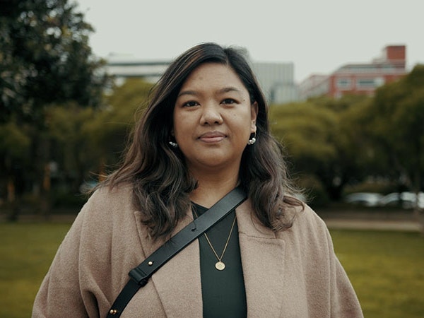 Maria Milmine, 2022. Photo by Julie Zhu. Te Papa A woman stands in a park looking into the camera on an overcast day