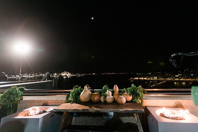 A selection of gourds on a table at Te Papa overlooking Wellington Harbour. The sun has not yet risen, and cameras hover in the air ahead of broadcasting of the ceremony