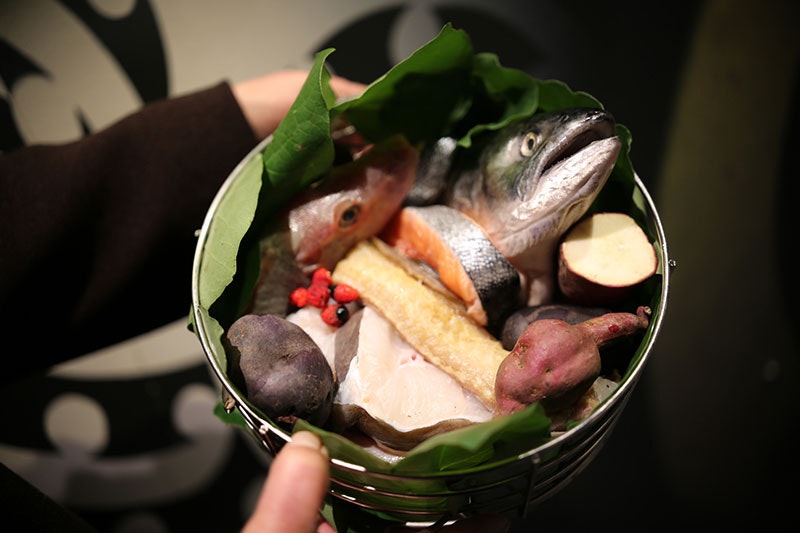 A bucket full of kūmara, salmon, fish, and other vegetables
