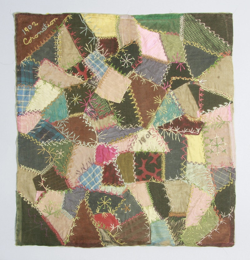A patchwork cushion cover of many pieces of fabric.