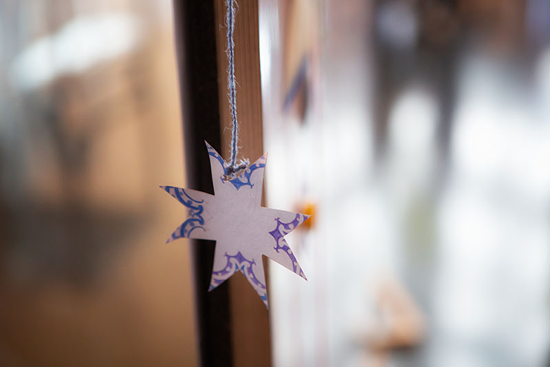 A handmade star of cardboard hangs