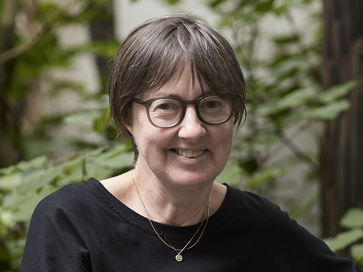 Lissa Mitchell. Photo by Yoan Jolly A head and shoulder image of a woman in glasses smiling at the camera.