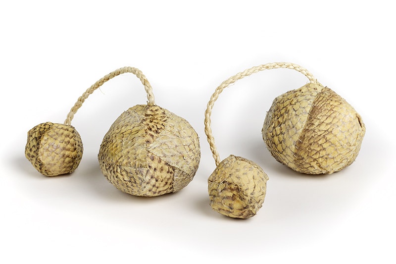 Two balls made of fish skin each with a cord for hanging on to.