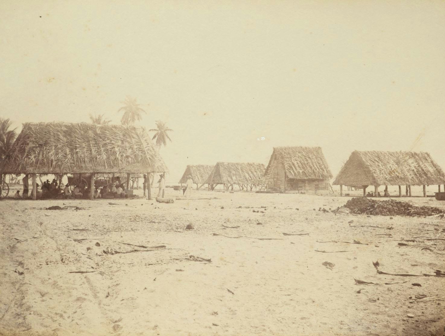 Sepia photograph of huts with people sat under them