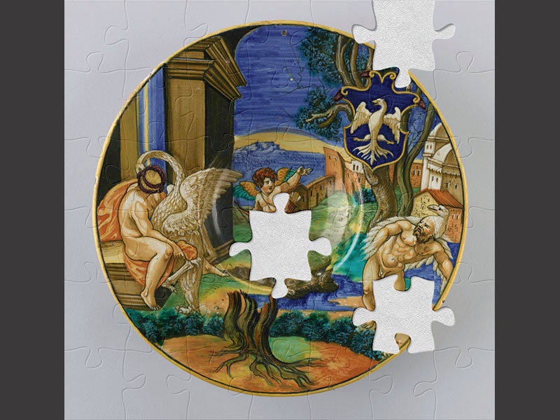 Ornamental plate with gold rim and a scene painted on it depicting a cherub and two men with swans