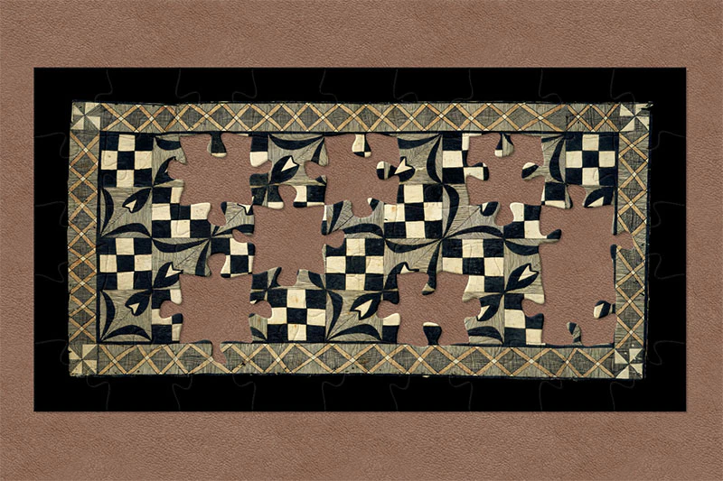 Tapa cloth. The border is a network of orange Xs, while the internal patterns alternate between checkerboards and flowers