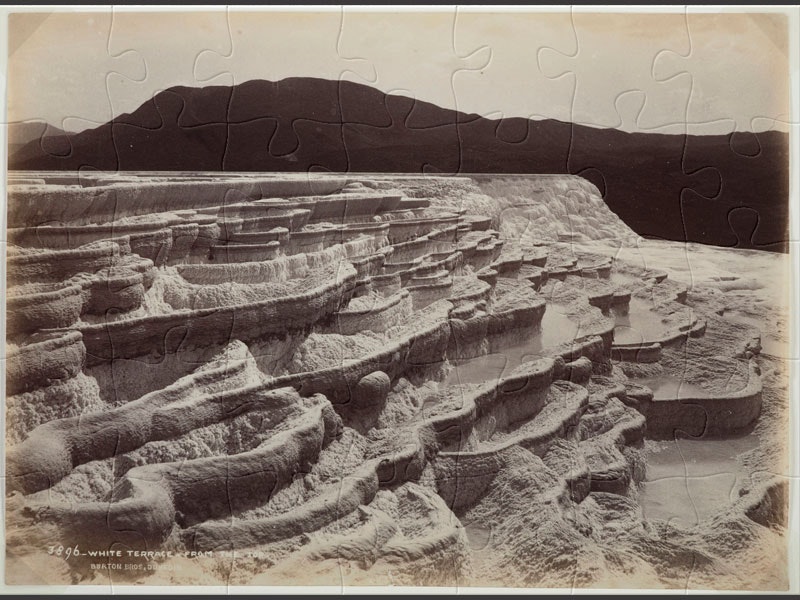 White Terrace from the top, 10 November 1885, New Zealand, by Burton Brothers studio, Alfred Burton. Black and white photo of silica geothermal pools in a terrace formation with dark mountains in background