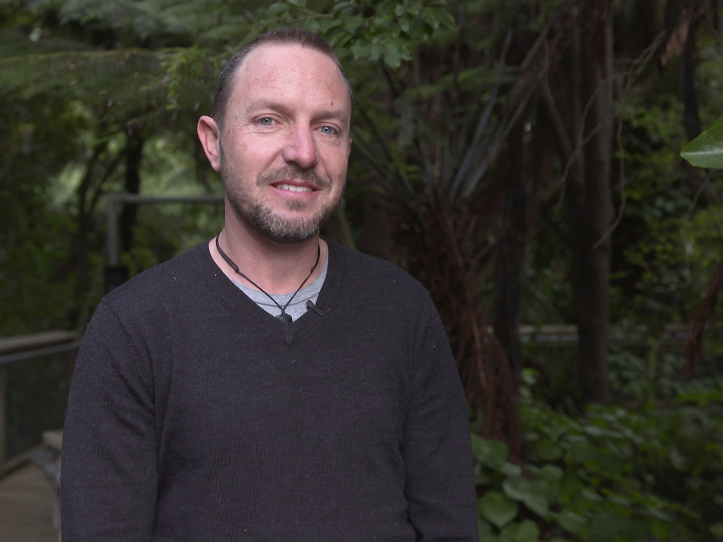 A man standing in front of trees