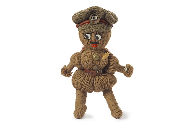A doll made of wool that is decorated as a soldier.