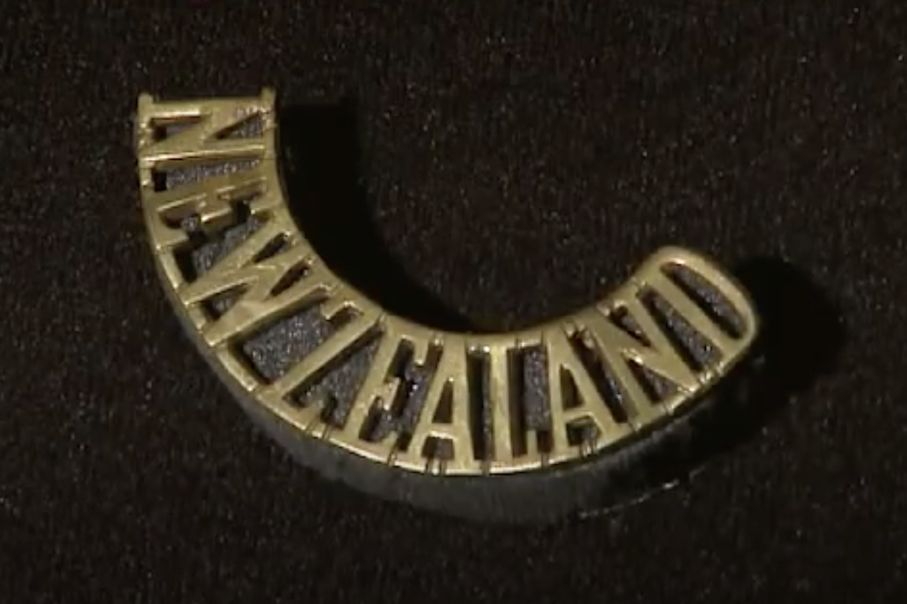 A gold-coloured badge that says the words New Zealand