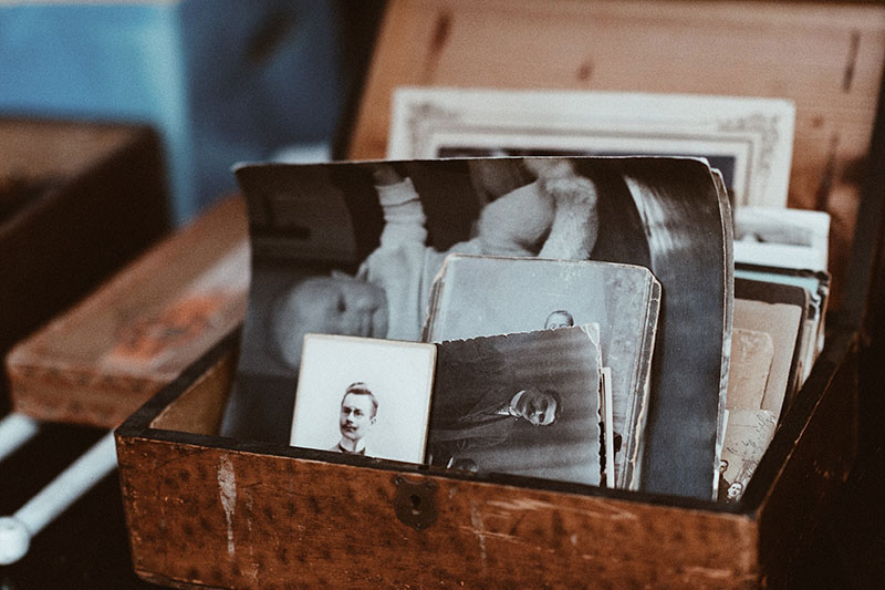 Small wooden box containing a collection of old black and white portraits