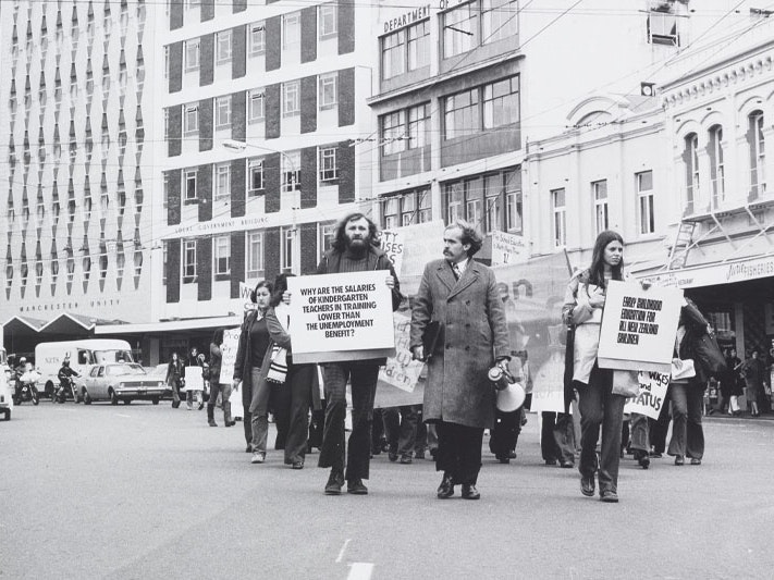 Kindergarten Teachers Protest, Lambton Quay, Wellington (detail), 1970s, by Ans Westra, gelatin silver print. Purchased 1993 with New Zealand Lottery Grants Board funds. Te Papa (O.010245/03) Black and white photo of protestors marching down a major road in Wellington’s city centre