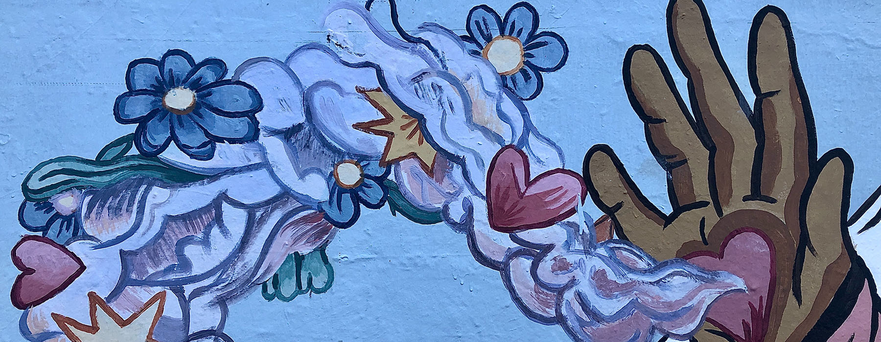 Paintings on a fence of an open hand held up with a love heart on the palm, emitting smoke filled with hearts and flowers