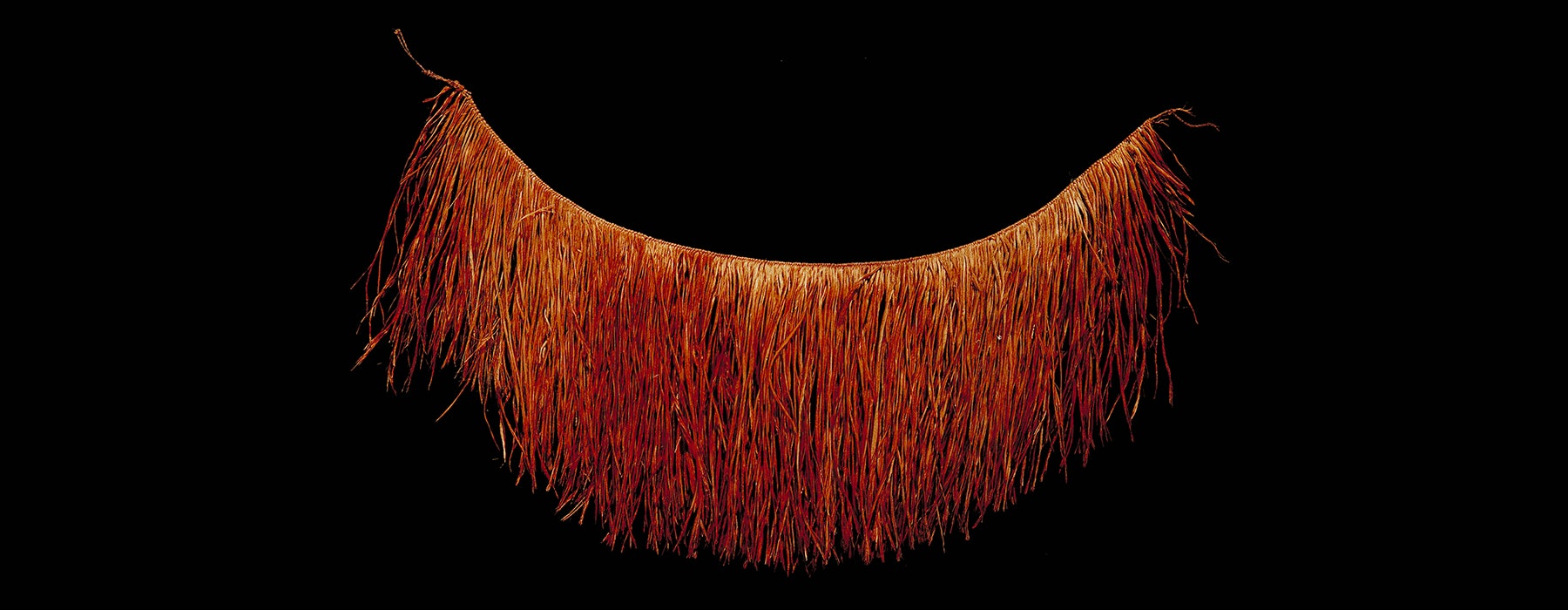 A red skirt made of coconut fibre that has been opened out over a black background.